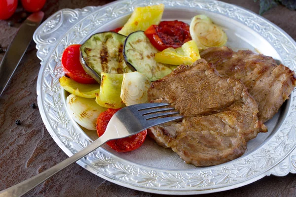 Bife grelhado carne de porco e legumes grelhados em pedra marrom ba — Fotografia de Stock