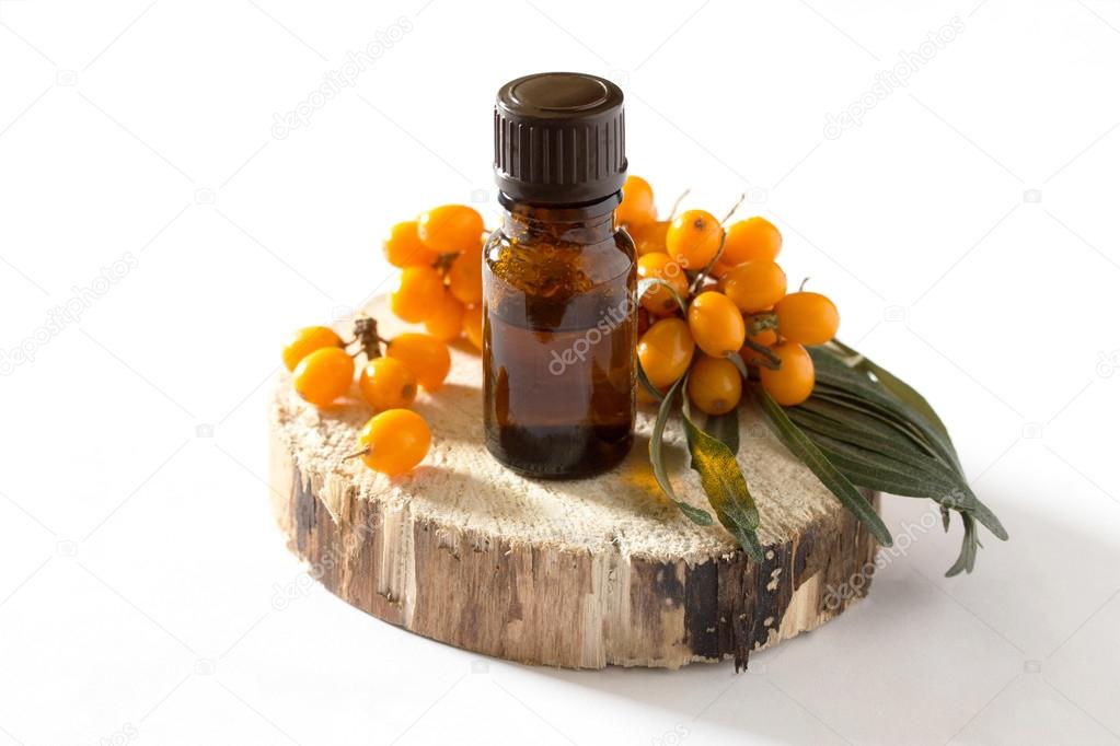 Buckthorn berries branch and sea buckthorn oil on a white backgr