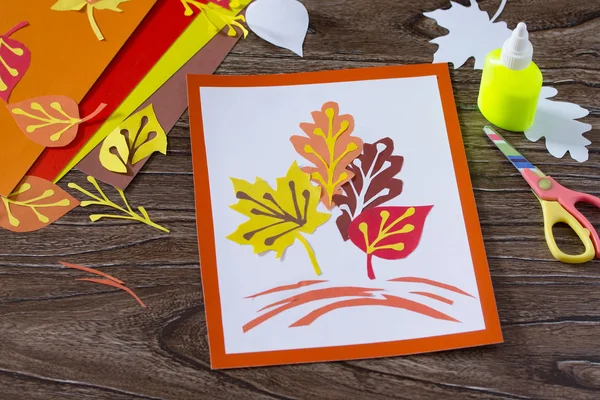 Podzimní listí z barevného papíru na dřevěné pozadí. Listů — Stock fotografie