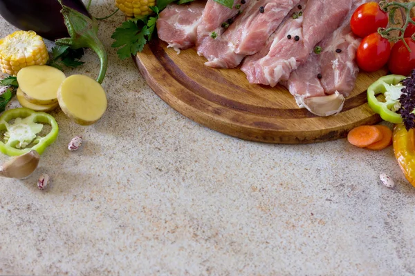 Lomo de cerdo de carne fresca cruda con verduras en un jabalí de corte —  Fotos de Stock