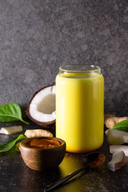 Sağlıklı bir içki. Ayurvedic altın hindistan cevizi sütü ve taş bir tezgahın üstünde zencefil tozu. Boşluğu kopyala.