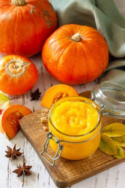 Baharatlı balkabağı püresi ve ahşap bir masada balkabağı.. 