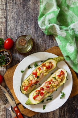 Sağlıklı yiyecekler. Köy ahşap masada et ve domatesle doldurulmuş fırında kabak. En üstteki düz yerde. Metnin için boş yer.