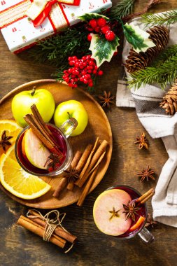 Portakal, elma ve baharatlı kış Noel içeceği. Kırsal masada baharatlı cam bardakta sıcak şarap. Üst görünüm düzlüğü. 