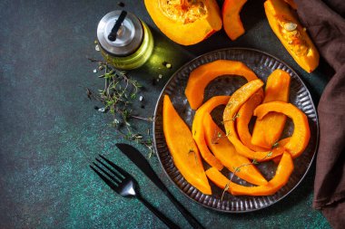 Balkabağı kış tatlısı. Taş bir tezgahın üstünde ballı balkabağı dilimleri ve kekik. En üstteki düz yerde. Boşluğu kopyala.