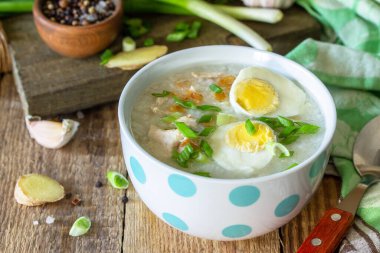 Sıcak çorba tavuğu, zencefilli pilav ve kırsal masada bir kasede sarımsak..