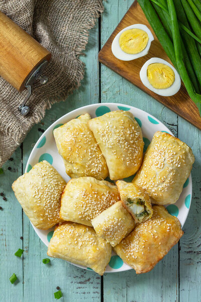Ukrainian or Russian cuisine. Baked small pies with egg and green onions, spring vitamin baked goods. Top view flat lay. 