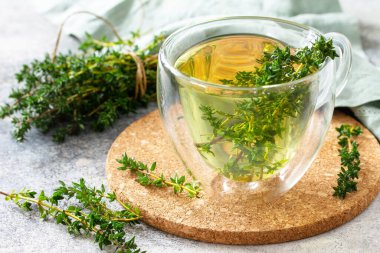 Terapötik bitki çayı. Sıcak bir fincan kekik çayı, hafif bir tezgahın üstünde.. 