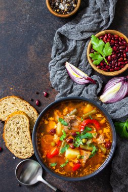 Ev yapımı et çorbası, sığır eti ve fasulye güveci, taş bir masanın üstünde sebzeler. En üstteki düz yerde. Boşluğu kopyala.