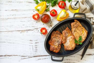 Barbekü partileri menüsü. Kemiğin üzerinde pişmiş domuz filetosu ve kırsal ahşap masada dökme demir bir tavada baharatlar. En üstteki düz yerde. Boşluğu kopyala.