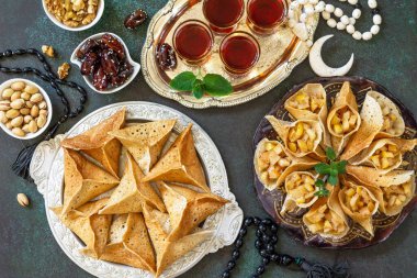 Arap mutfağı. Ramazan Kareem Festivali. Ramazan menüsü, Mısır doğulu tatlı: çeşitli Arap krep katayef ve hurma, şam fıstığı. Üst görünüm.