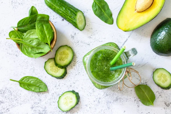 Yeşil smoothie tarifi. Sağlıklı beslenme ve beslenme, vegan ve alkali içecekler. Taze salatalık, avokado ve gri bir taşın üzerinde ıspanak. Üst Manzara. Düz yatıyordu. 
