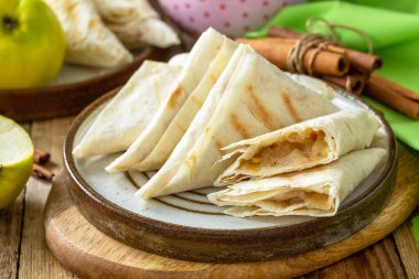 Kahvaltı için elmalı pasta. Ahşap bir masada elmalı ve tarçınlı ızgara lavaş üçgeni..