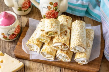 Kahvaltı, piknik, öğle yemeği veya atıştırmalık konsepti. Köy peyniri, peynir ve ıspanaklı lavaş rulosu..