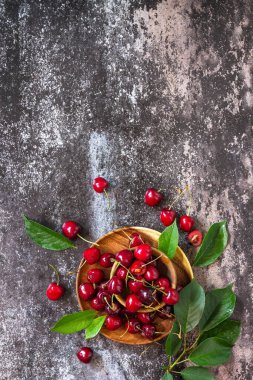 Taze taze organik dut. Koyu taştan bir masanın üstünde kırmızı kiraz. Üst görünüm düz arkaplan. Boşluğu kopyala.