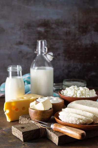 Set of different dairy organic products (milk, sour cream, cottage cheese, yogurt and butter) on a rustic wooden countertop. Copy space.