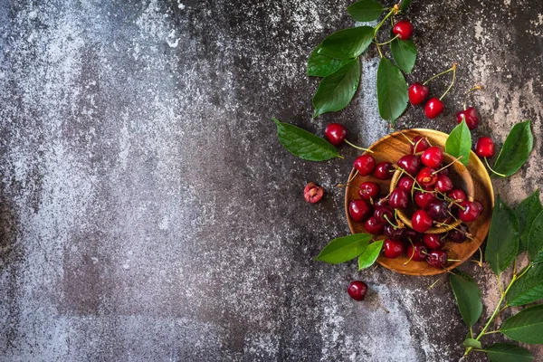 Taze taze organik dut. Koyu taştan bir masanın üstünde kırmızı kiraz. Üst görünüm düz arkaplan. Boşluğu kopyala.