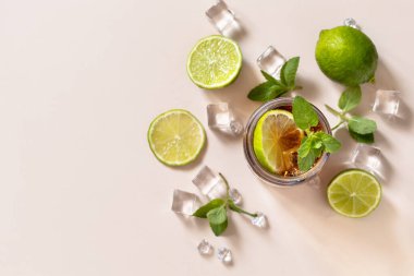 Küba Libre alkollü içeceği, buzlu kola ya da pastel kahverengi arka planda limonata. Üst görünüm düz arkaplan. Boşluğu kopyala.