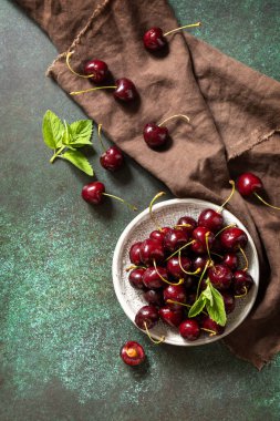 Olgun organik dut. Koyu taştan bir masanın üstünde taze kırmızı kiraz. Üst görünüm düz arkaplan. Boşluğu kopyala