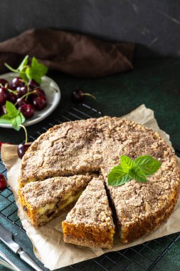 Süzme peynirli köylü turtası. Süzme peynirli kek, kiraz ve çırılçıplak taş bir tezgahın üstünde. Boşluğu kopyala.
