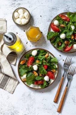 Sağlıklı diyet salatası roka, mozzarella, midye ve salata sosu gri bir masa üstünde. Üst görünüm düz arkaplan. Boşluğu kopyala