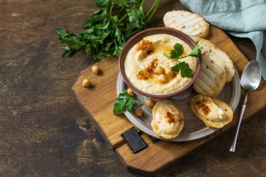 Orta Doğu, Humus Arap mutfağı. Vejetaryen soslu ev yapımı nohut, zeytinyağlı, kırmızı biberli ve kırsal bir masada. Boşluğu kopyala.