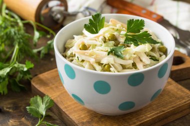 Taze lahana, kalamar, salatalık ve kırsal bir masada yeşil bezelye..