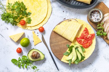 Sandviç ve malzemeler için pişirme işlemi. Gri bir masanın üstünde avokado, roka ve peynirli Meksika usulü sandviç.. 