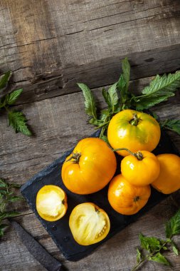 Mutfak ahşap masasında taze, taze, olgun organik sarı domatesler. Diyet menüsü ve hasat konsepti. Üst görünüm düz arkaplan. Boşluğu kopyala.