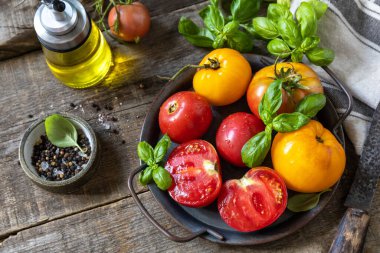 Taze çiğ organik sarı, kırmızı domates ve ahşap bir masada salata pişirmek için malzemeler..