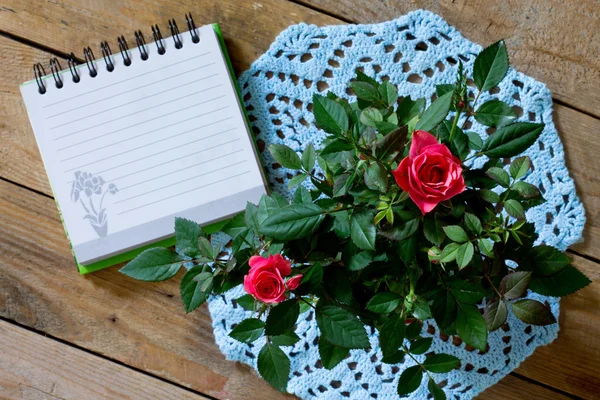 Róże na niebieski serwetka z dzianiny i podkładki do pisania — Zdjęcie stockowe