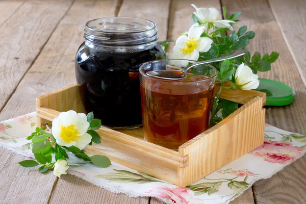 Hagebuttensirup für zu Hause auf einem Holztisch — Stockfoto