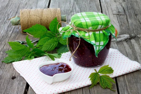 Marmellata di lampone in un vaso su un tavolo di legno — Foto Stock