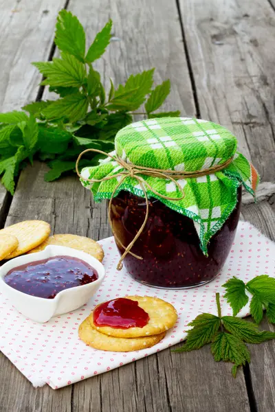 Marmellata di lampone in un vaso su un tavolo di legno — Foto Stock