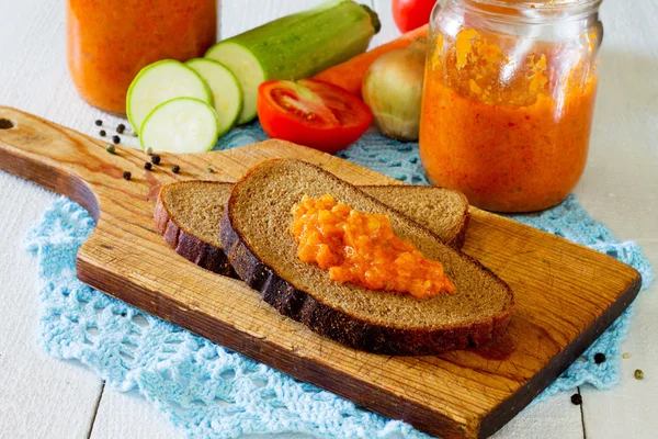 Sandwich com caviar de abobrinha em um fundo de tábuas de madeira — Fotografia de Stock