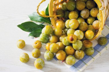 Beyaz ahşap bir masa üzerinde Erik meyveleri sarı