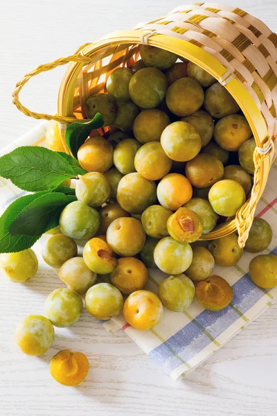 Beyaz ahşap bir masa üzerinde Erik meyveleri sarı