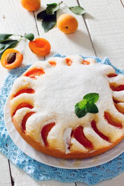 Beyaz ahşap zemin üzerinde kayısı ile sünger kek