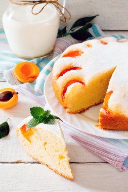 Beyaz ahşap zemin üzerinde kayısı ile sünger kek