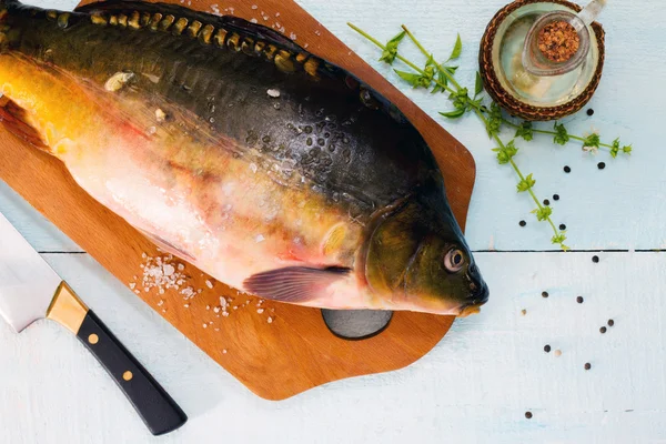 Сырая рыба с базиликом на деревянном столе — стоковое фото