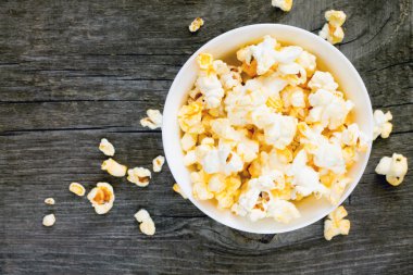 Koyu gri ahşap arka plan üzerinde tuzlu popcorn