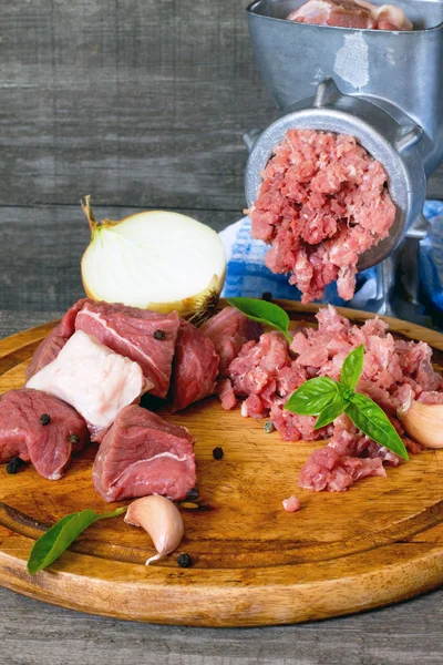 Яловичина, цибуля і сире м'ясо на темно-сірому дерев'яному столі — стокове фото