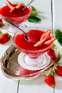 Beyaz ahşap zemin üzerine taze meyve ile çilekli jöle