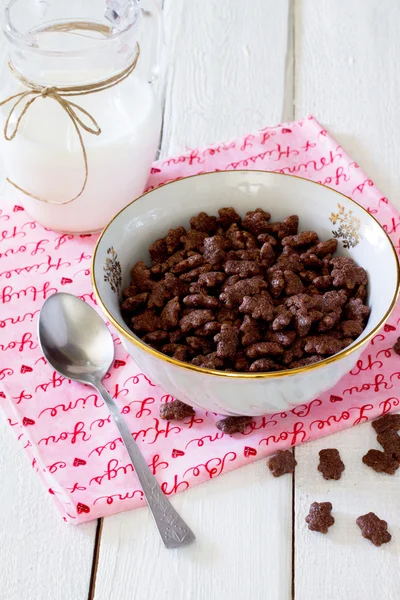 Jarra de bolas de chocolate de cereales de leche en una mesa de madera blanca —  Fotos de Stock