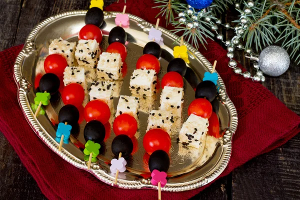 Canapés con queso feta y tomates cherry sobre una mesa de madera — Foto de Stock