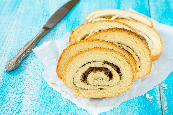 Bir kağıt üzerinde haşhaş tohumu strudel bir somun ekmek dilimi. — Stok fotoğraf