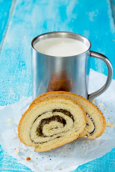 Un pain de pain frais avec des graines de pavot et une tasse de lait sur la languette — Photo