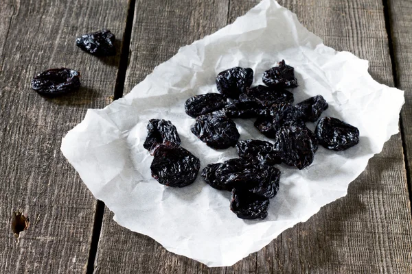 Dried plums on a dark background in a rustic style. — Stock Photo, Image