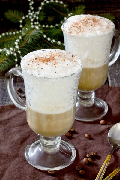 Cappuccino, egy fából készült asztal egy díszített karácsonyfa — Stock Fotó