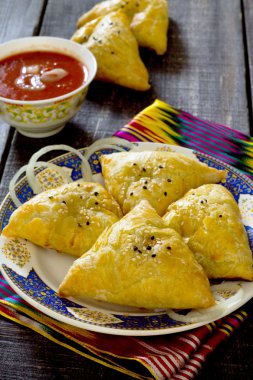 Geleneksel oryantal yiyecek samosa, etli turtalar rustik tarzda